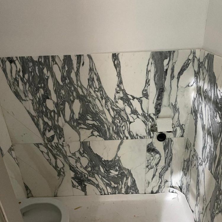 Ett kakel i vit och grå marmor