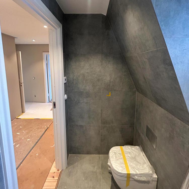 Ett badrum med grått kakel